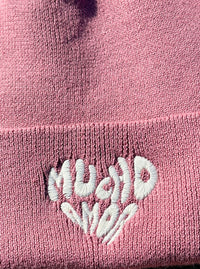 Zoom sur la broderie beige "Mucho Amor" du bonnet bordeaux
