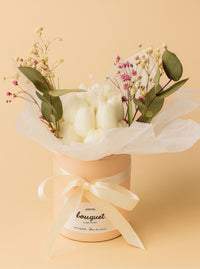 Bougie sculptée en bouquet dans un pot rose avec fleurs séchées et eucalyptus