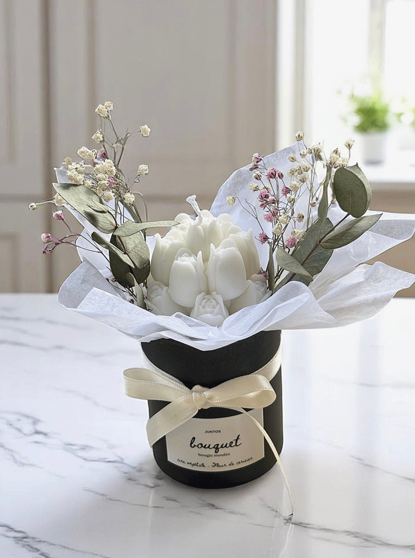 Bougie sculptée en bouquet dans pot noir avec fleurs séchées et eucalyptus
