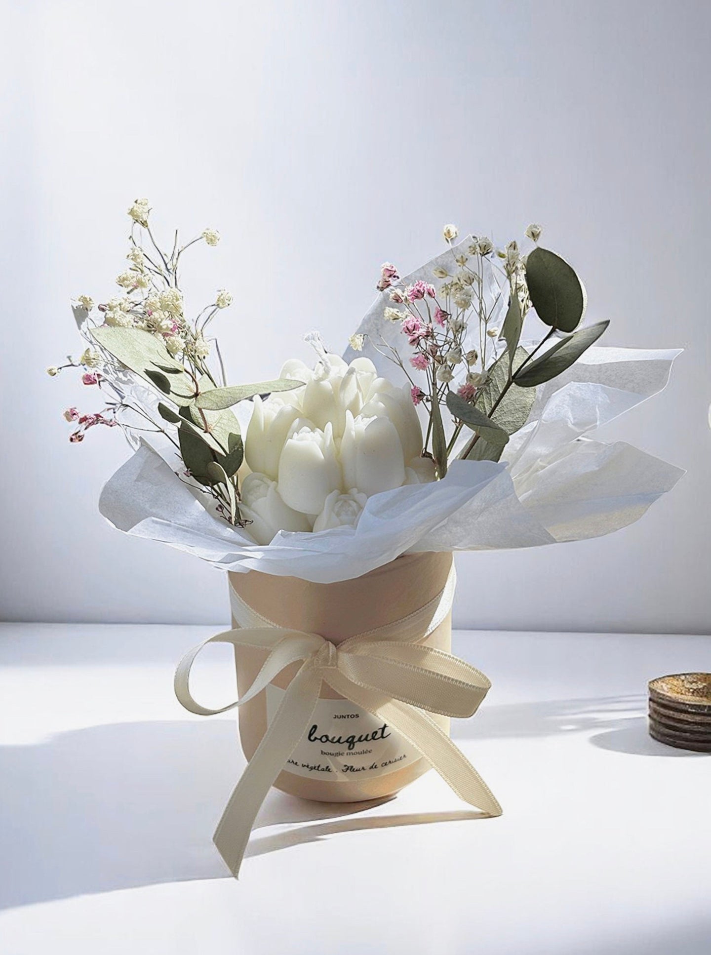 Bougie sculptée en bouquet dans un pot rose avec fleurs séchées et eucalyptus