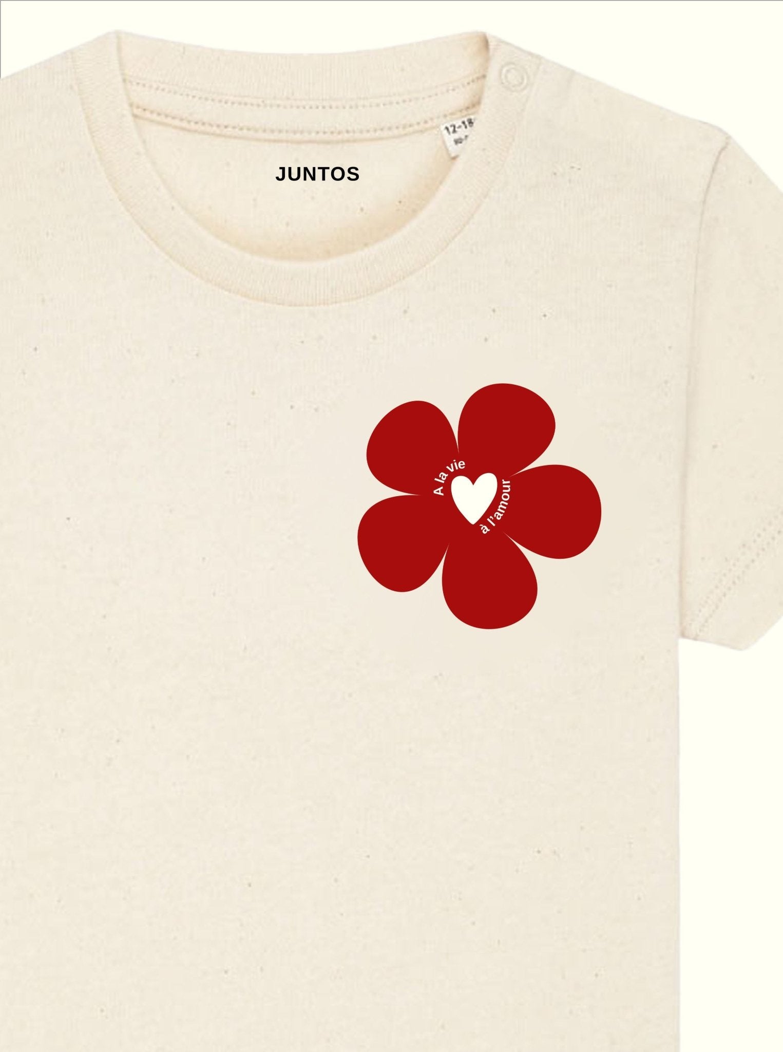 Gros plan sur la fleur bordeaux et l’inscription en blanc, T-shirt bébé beige en coton bio