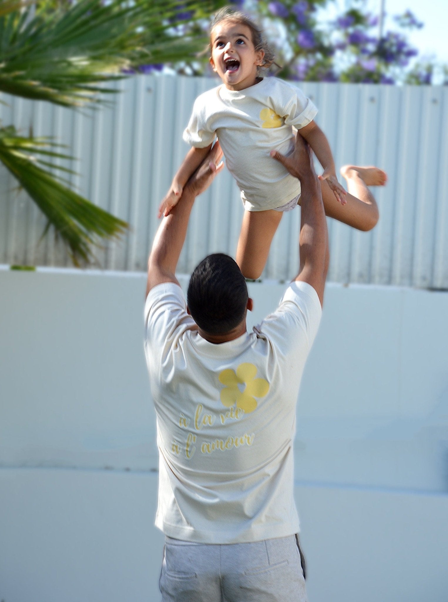 Dos du T-shirt bébé beige avec motif jaune « À la vie à l'amour » sur coton bio